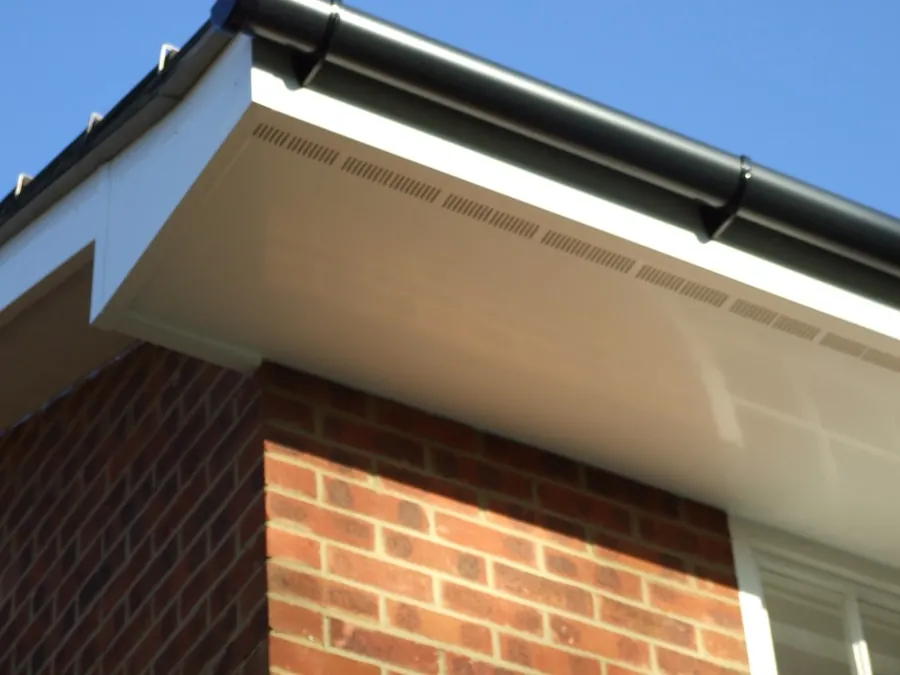 White uPVC fascia, vented soffit and black gutter at the eaves of a brick house